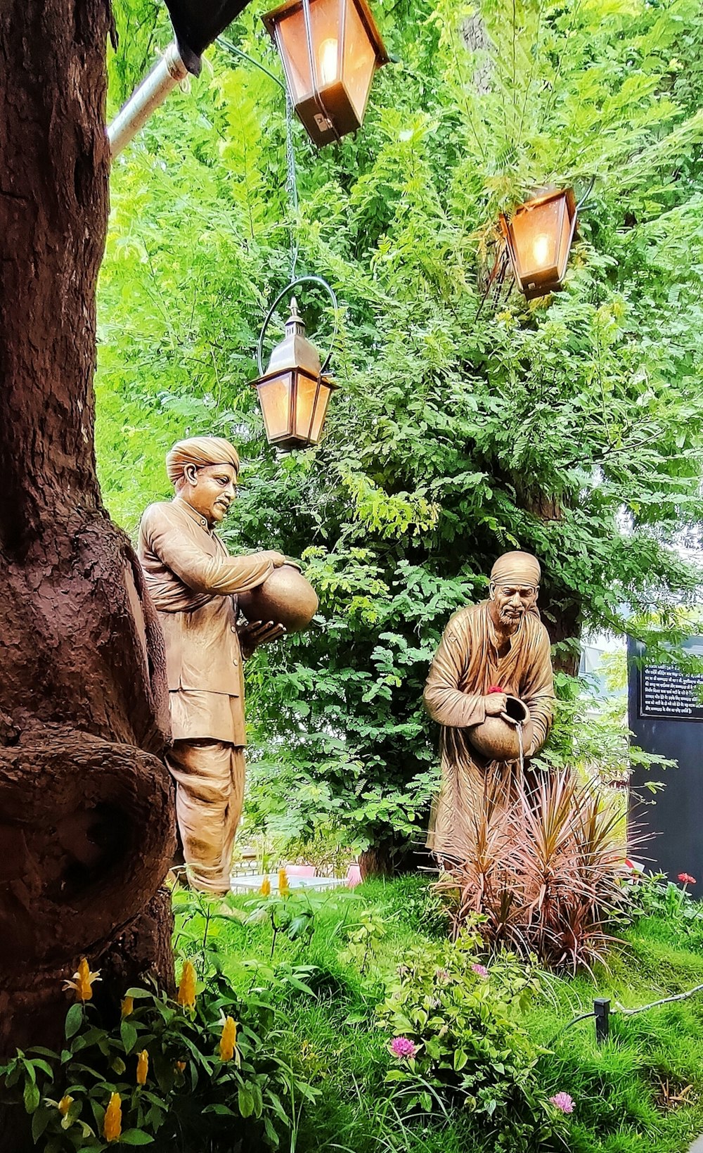 a couple of statues sitting next to a tree