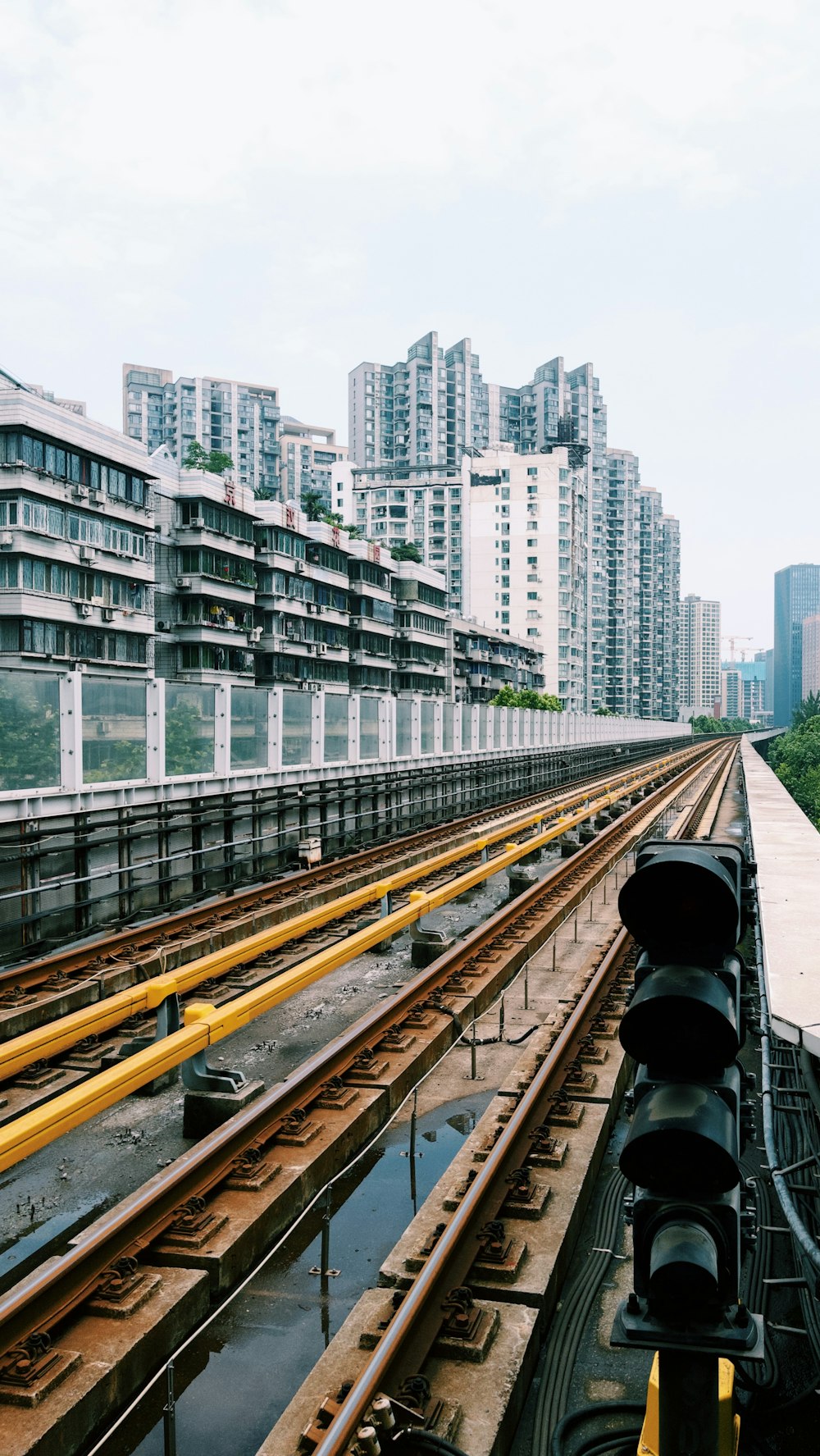 um trem viajando pelos trilhos do trem ao lado de edifícios altos