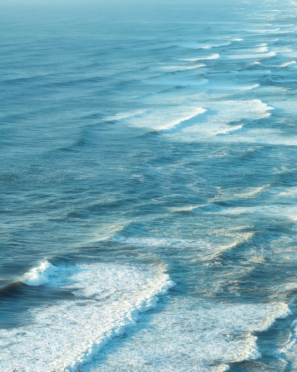 a view of a body of water with waves coming in