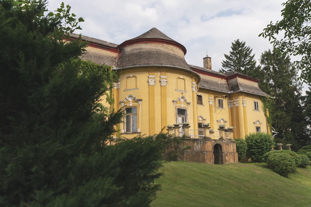 a large yellow building sitting on top of a lush green hillside