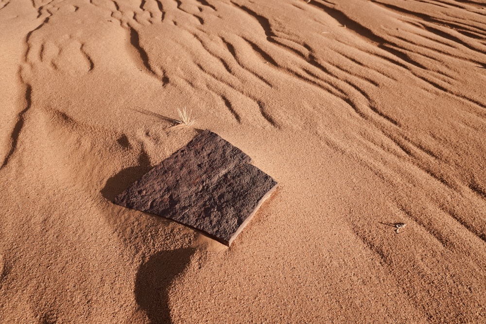 a rock sitting on top of a sandy beach