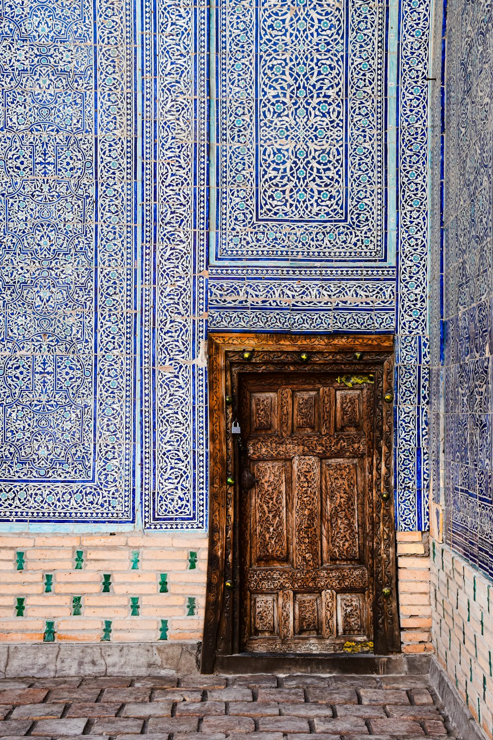 a wooden door in a blue tiled wall