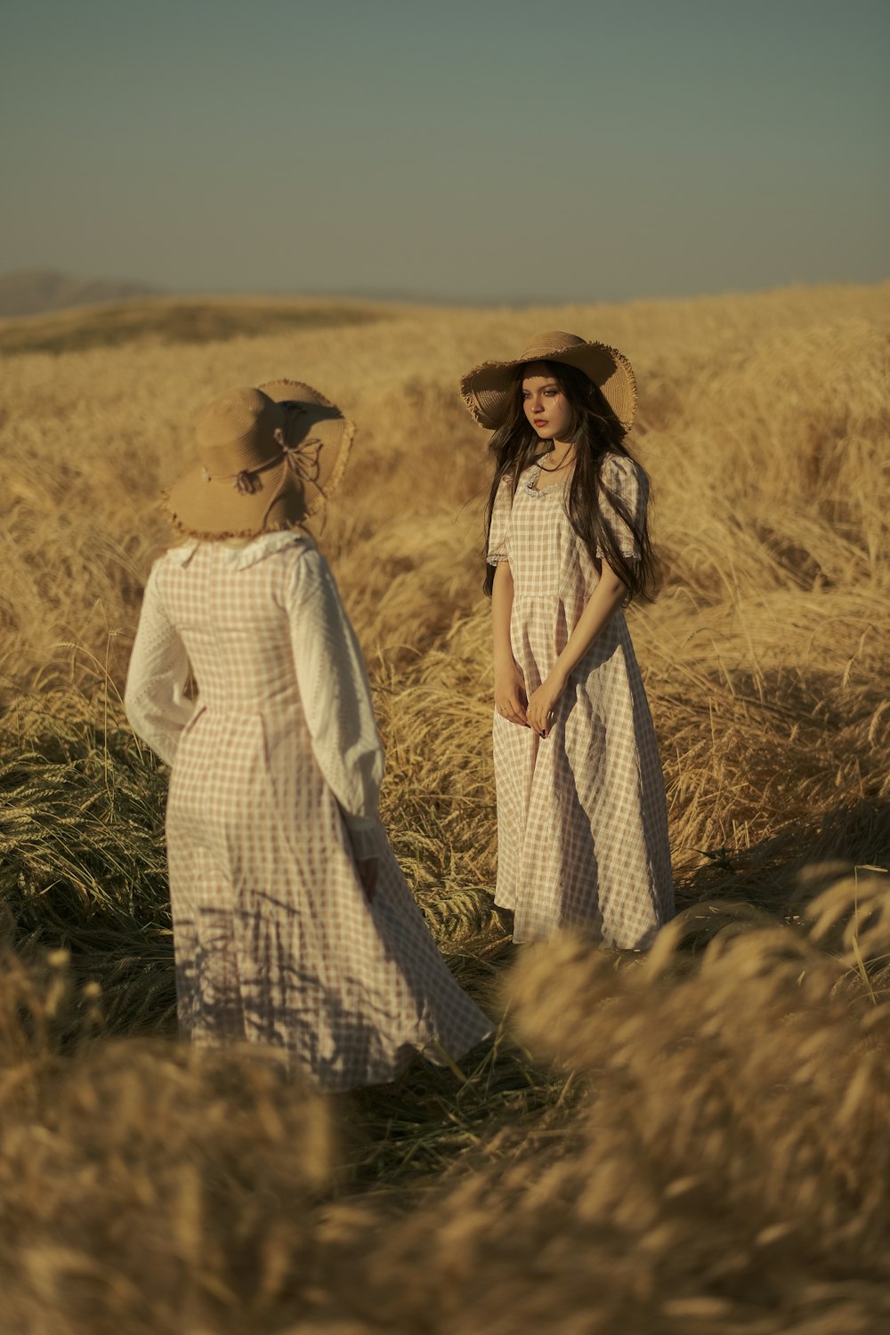 two women standing in a field of tall grass