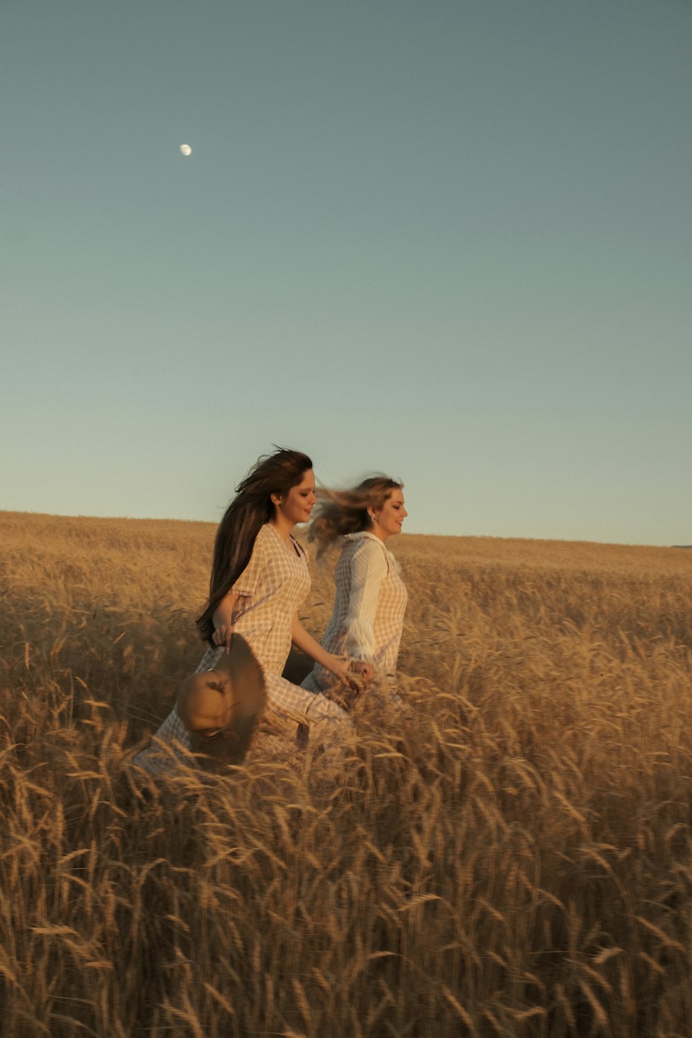 Dos mujeres caminando por un campo de hierba alta