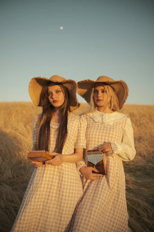 The sisters posing with their instruments in a sunlit studio.