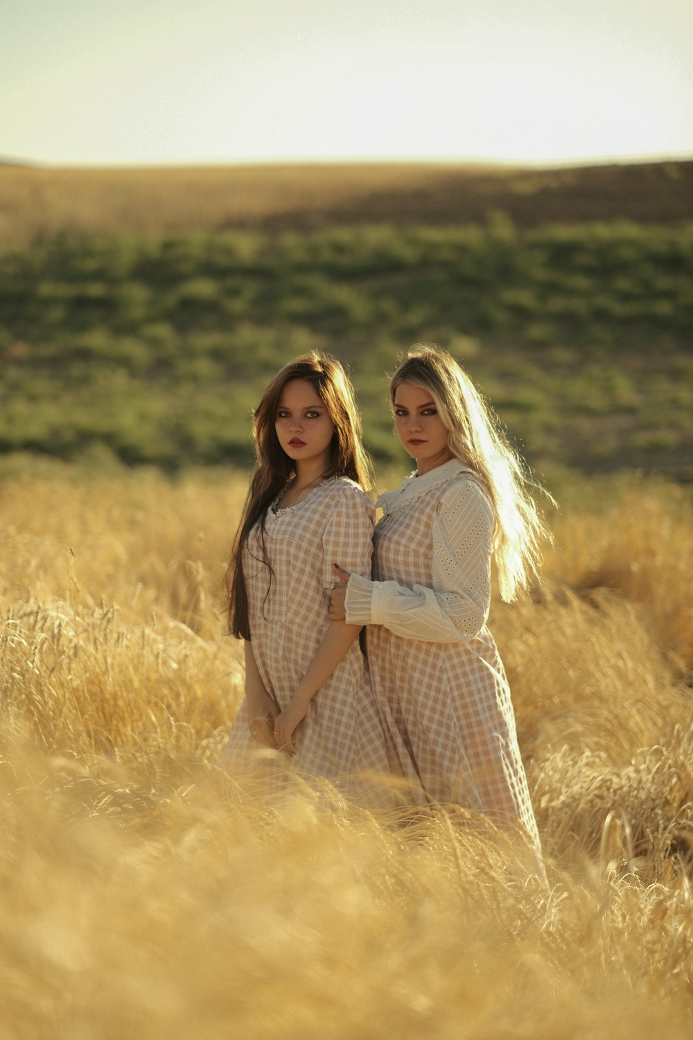 two women standing in a field of tall grass