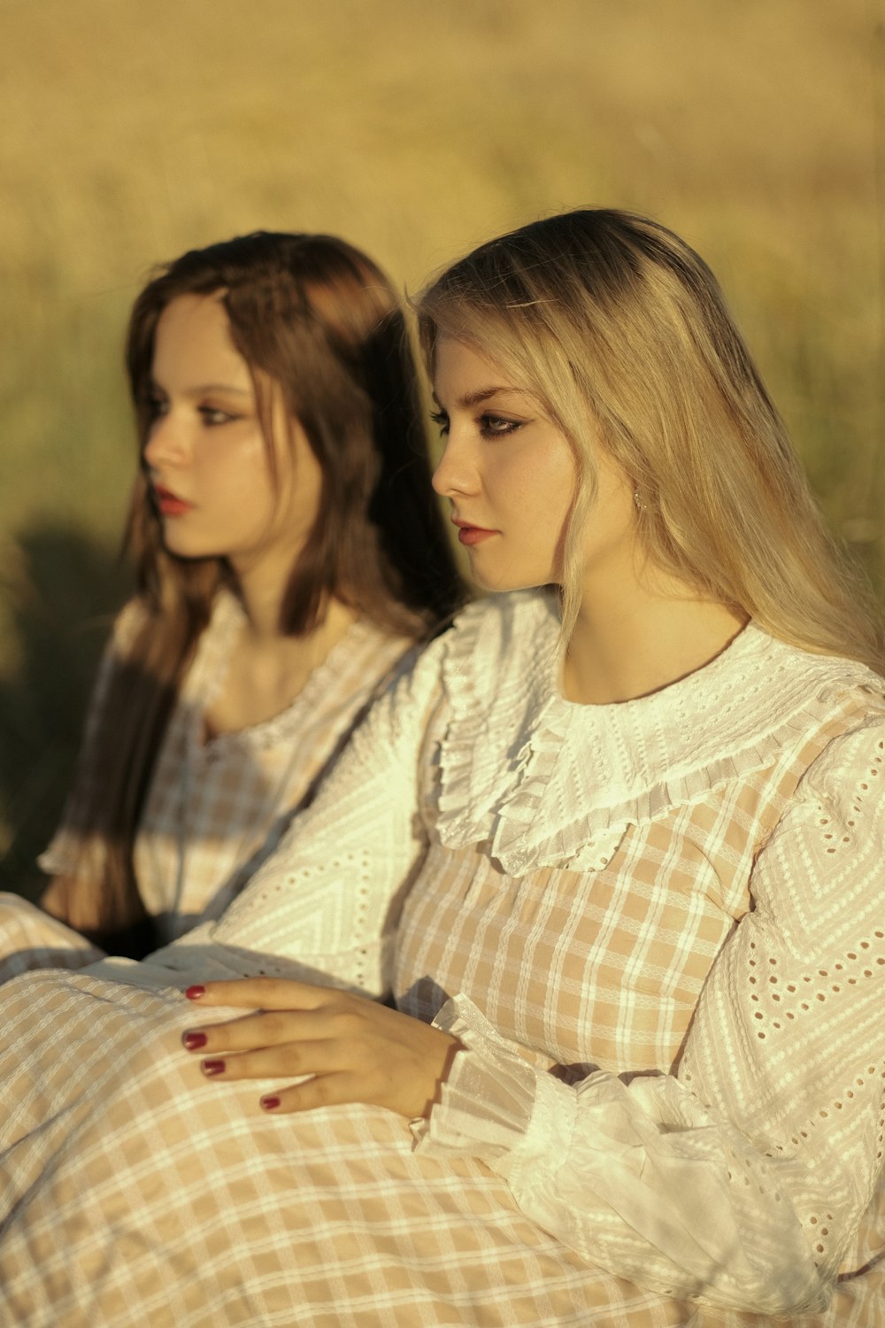 two beautiful young women sitting next to each other