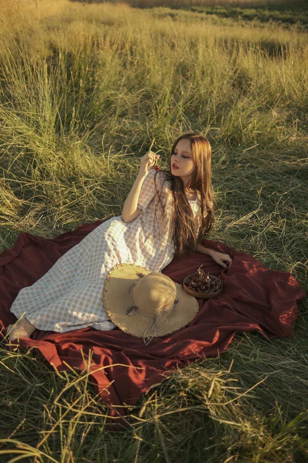 a woman sitting on a blanket in a field