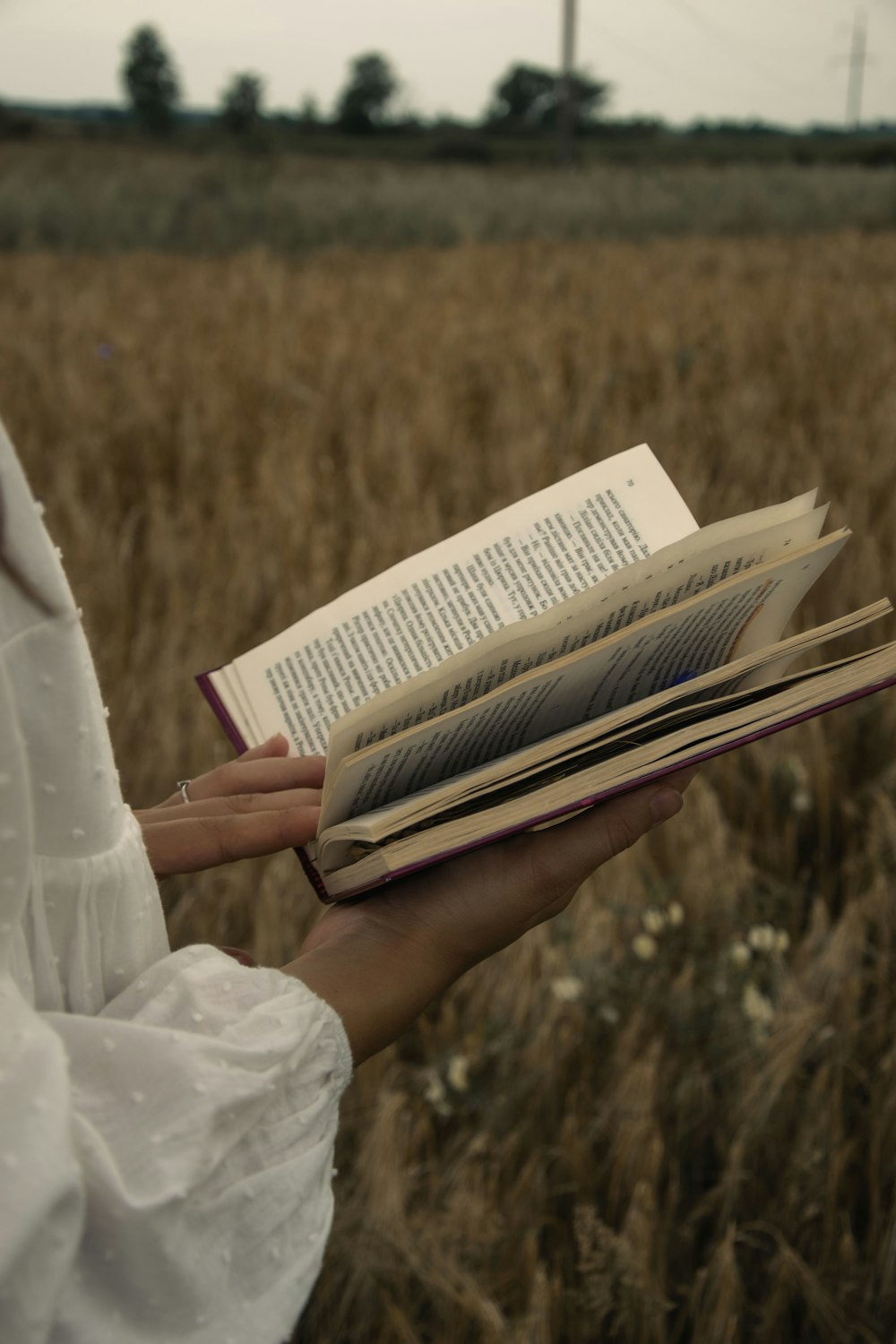 a woman in a white dress holding a book