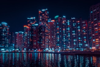 a city at night with lights reflecting in the water