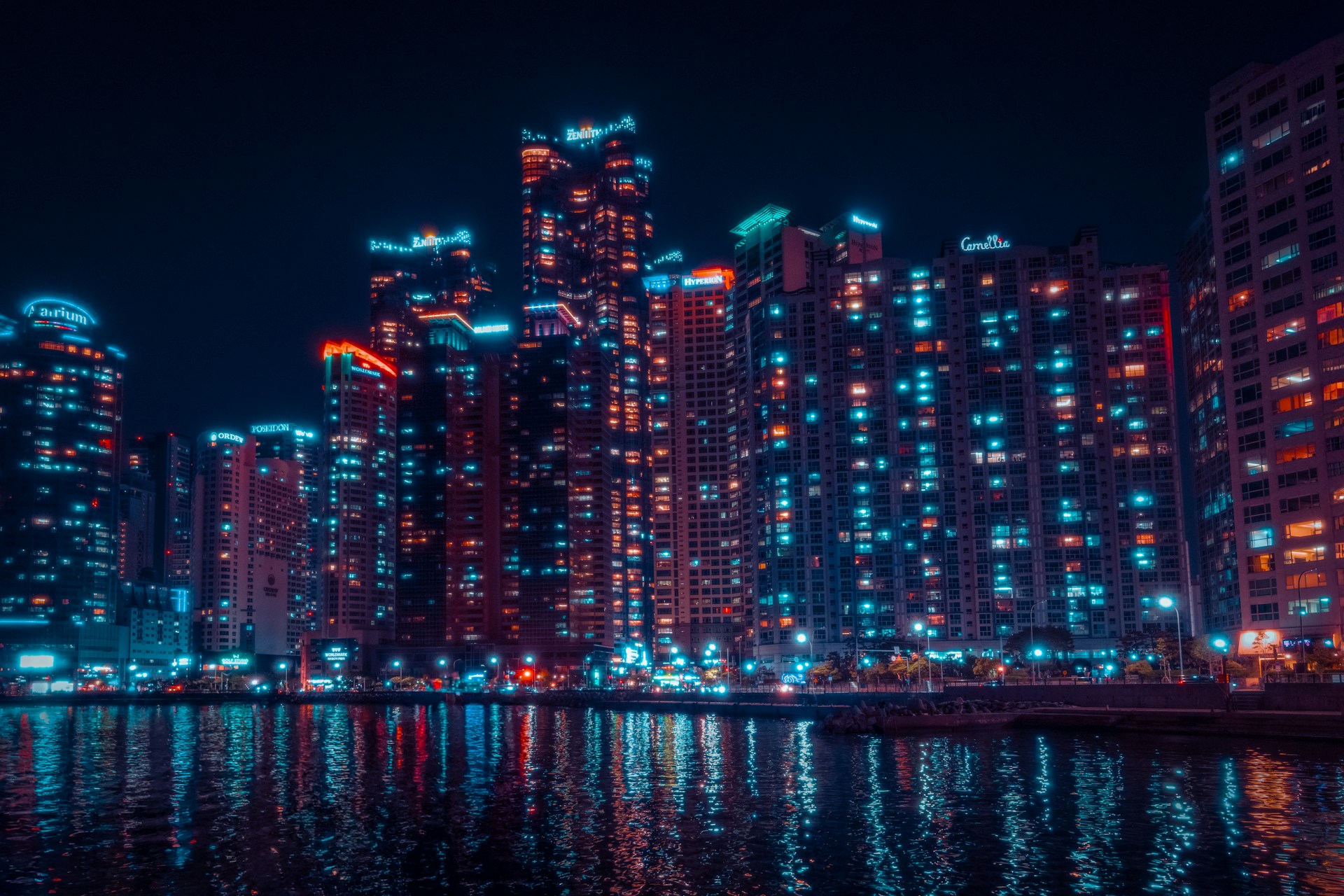 a city at night with lights reflecting in the water