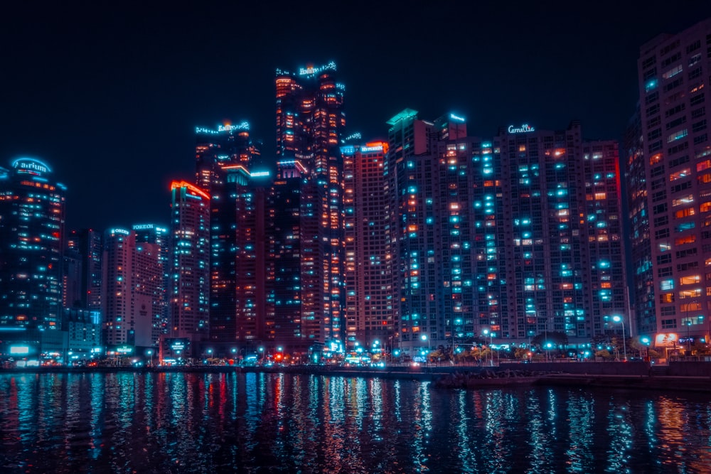 a city at night with lights reflecting in the water