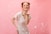 a woman standing in front of a pink background