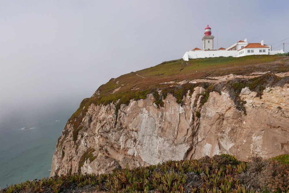 a lighthouse on top of a cliff overlooking the ocean