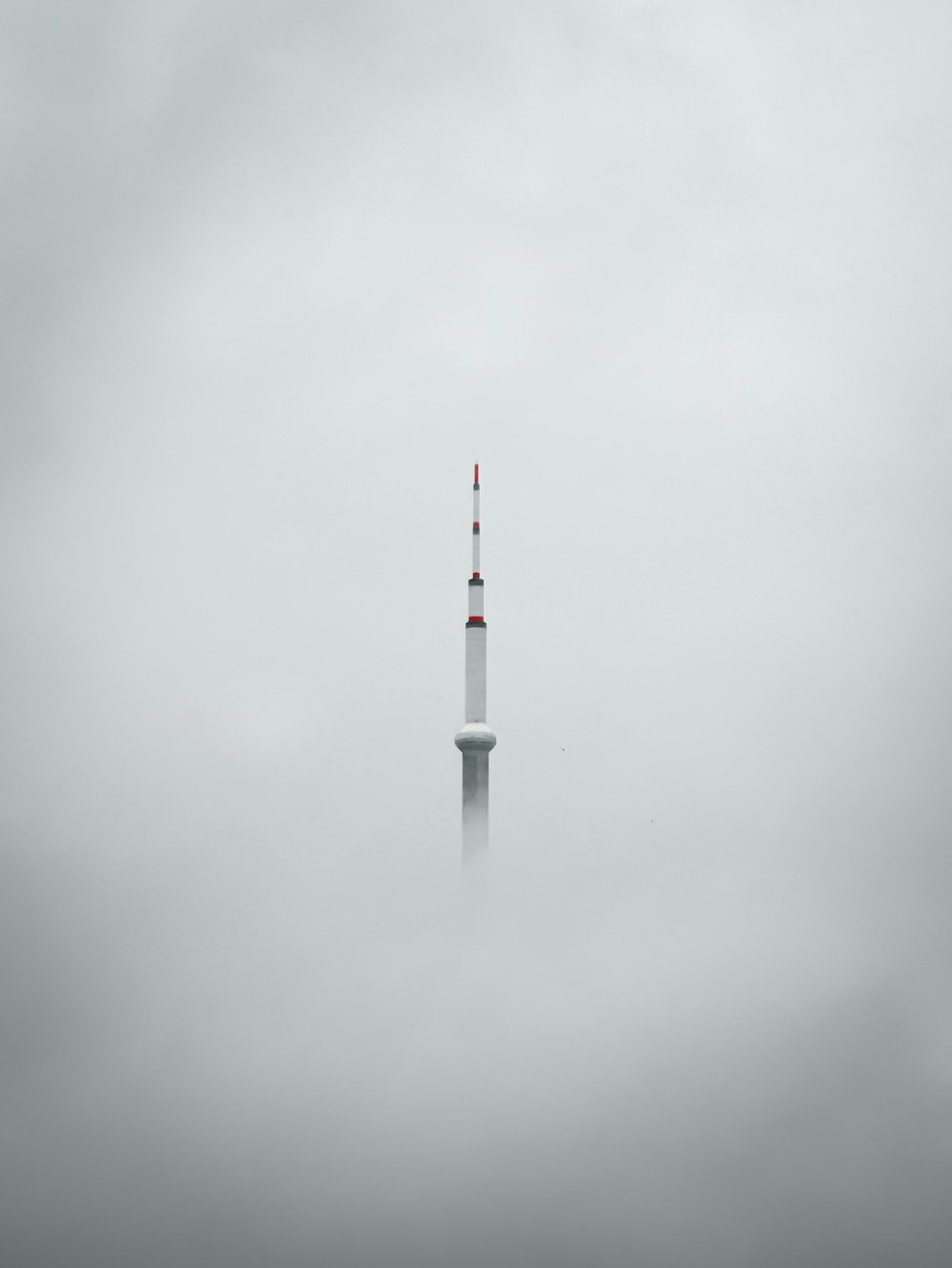 a very tall tower in the middle of a foggy sky