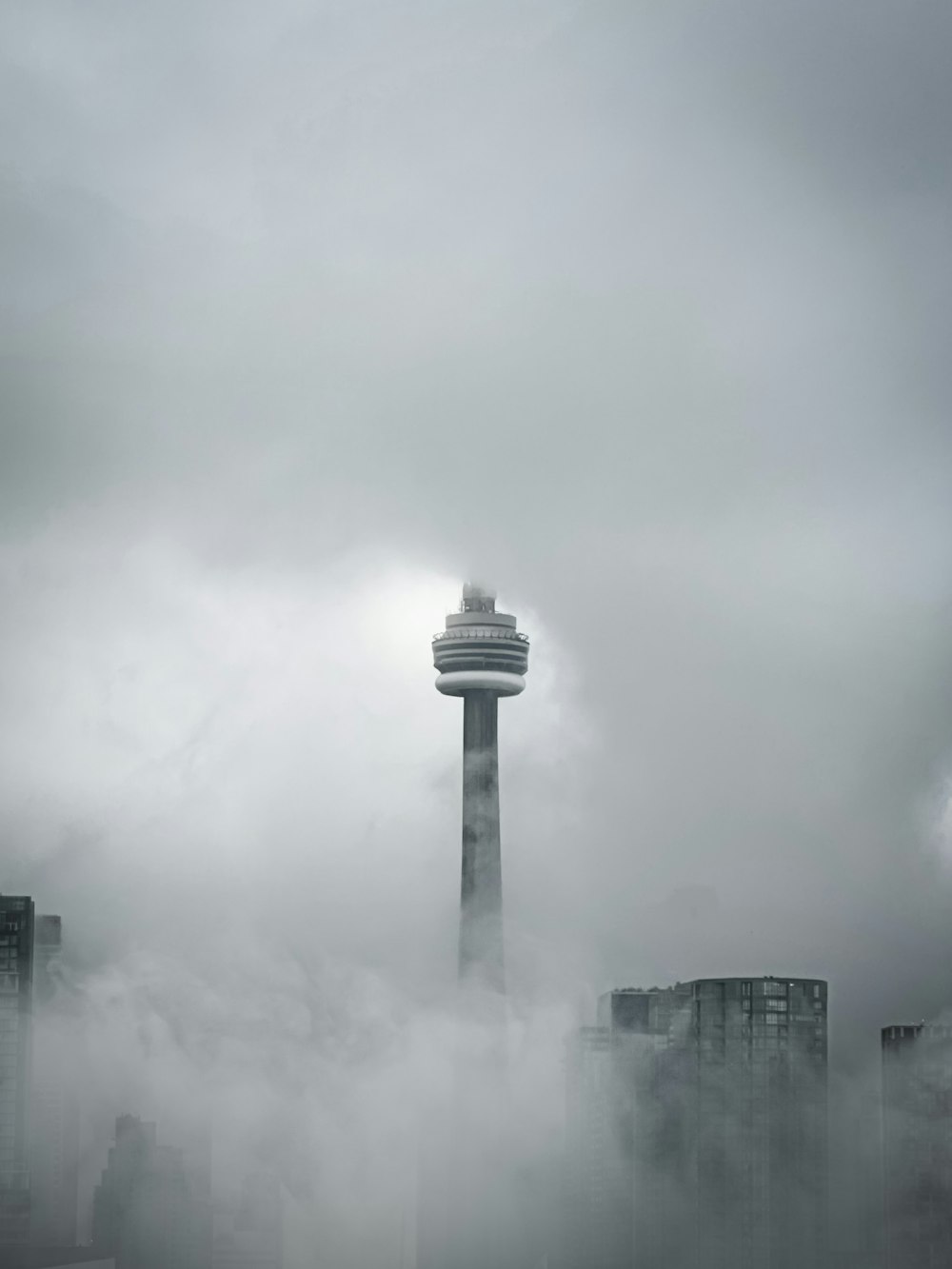a tall tower towering over a city covered in fog