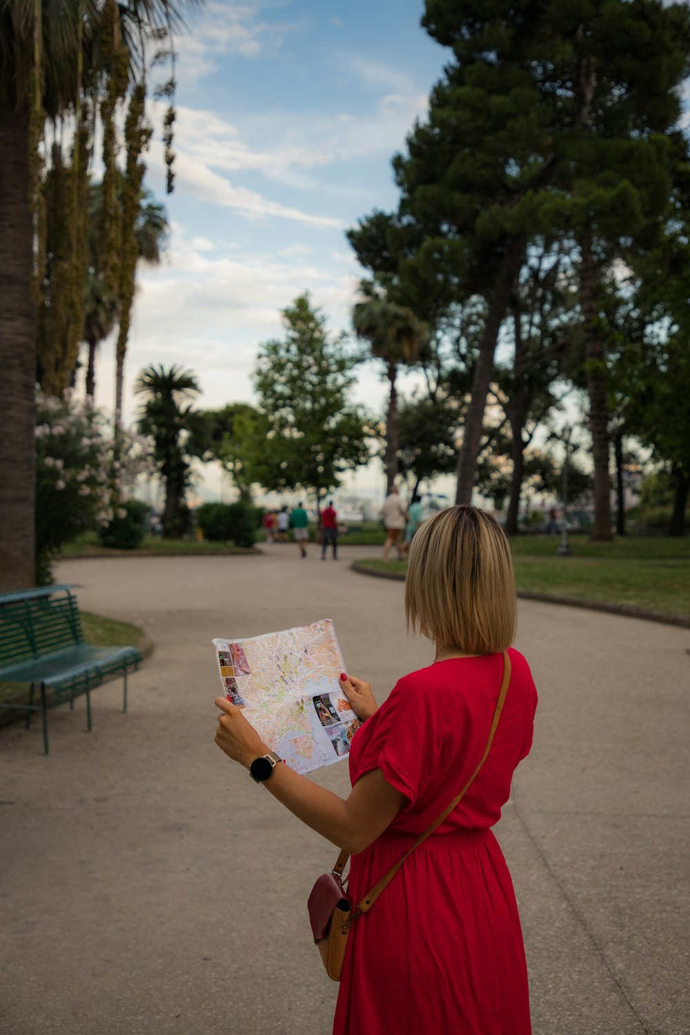 uma mulher em um vestido vermelho olhando para um mapa