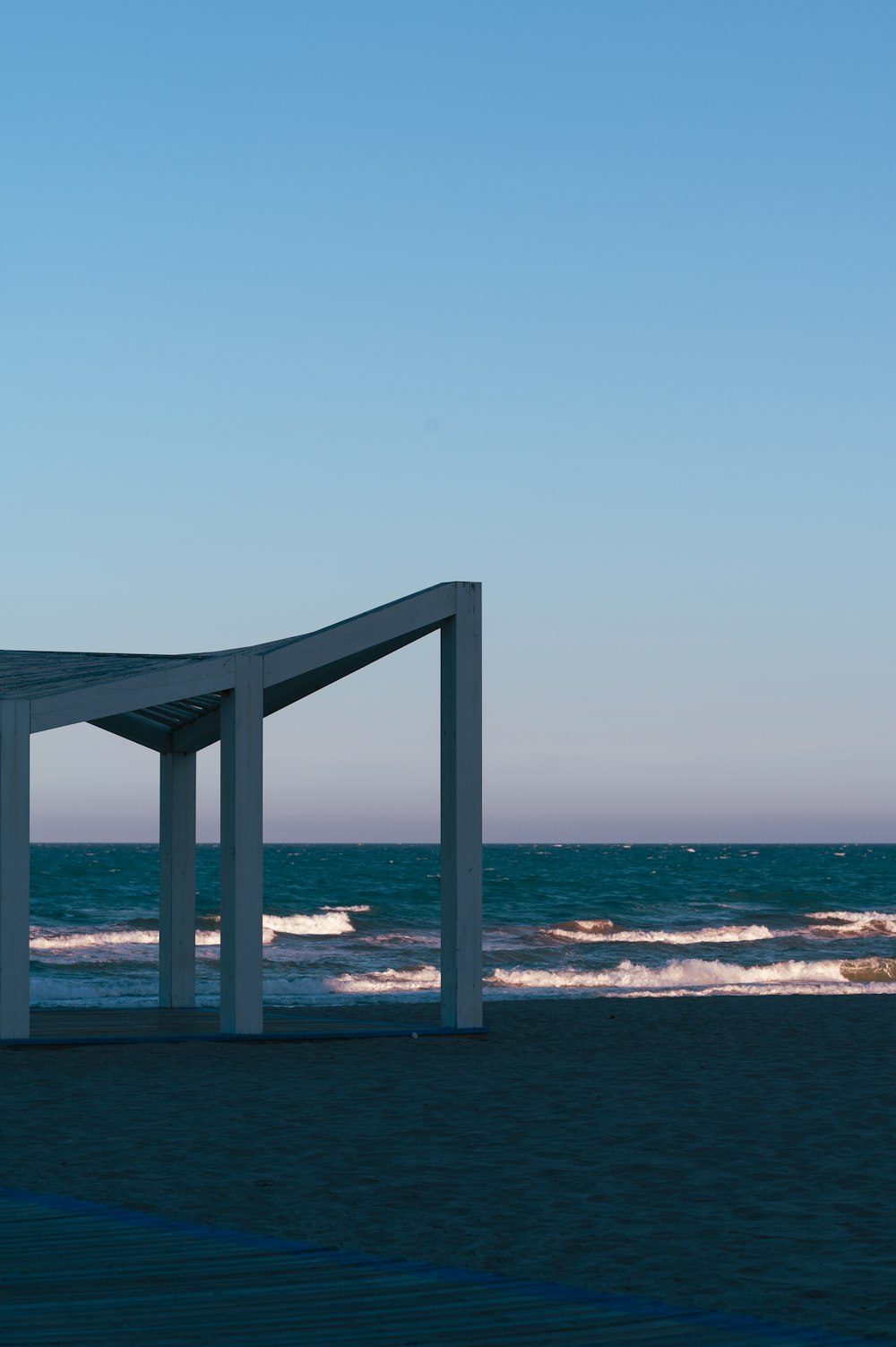 a white structure sitting on top of a sandy beach