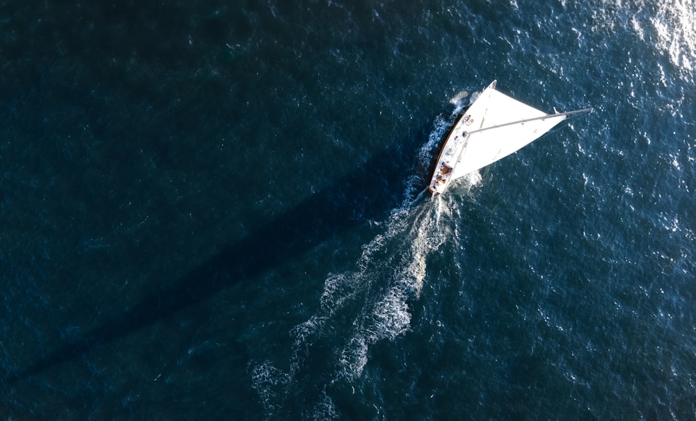 a small sailboat in the middle of the ocean