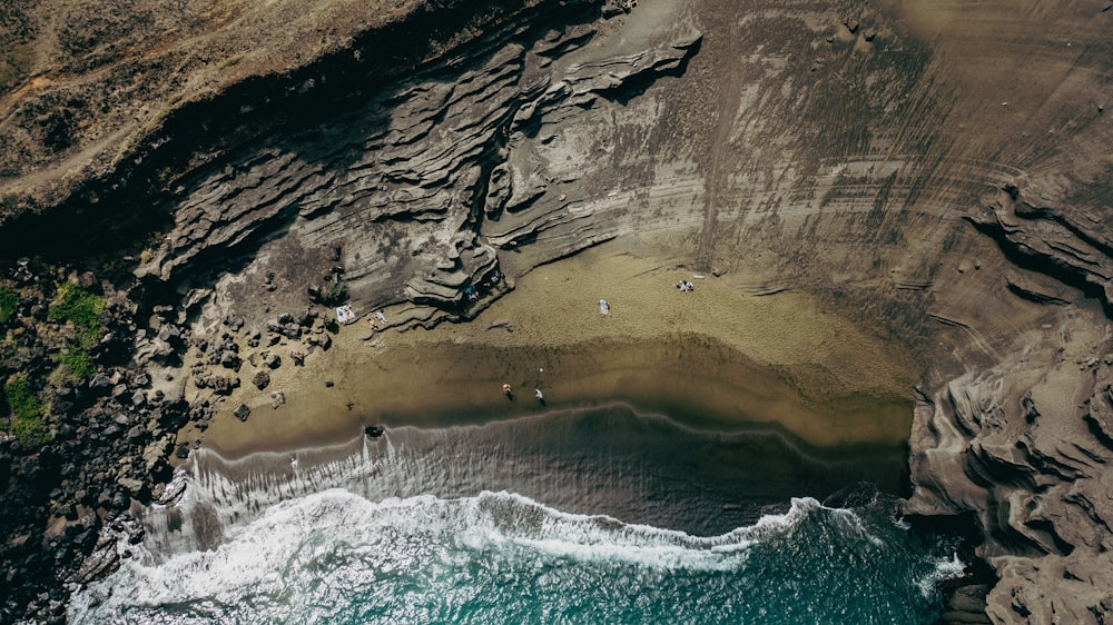 an aerial view of a beach with people in the water