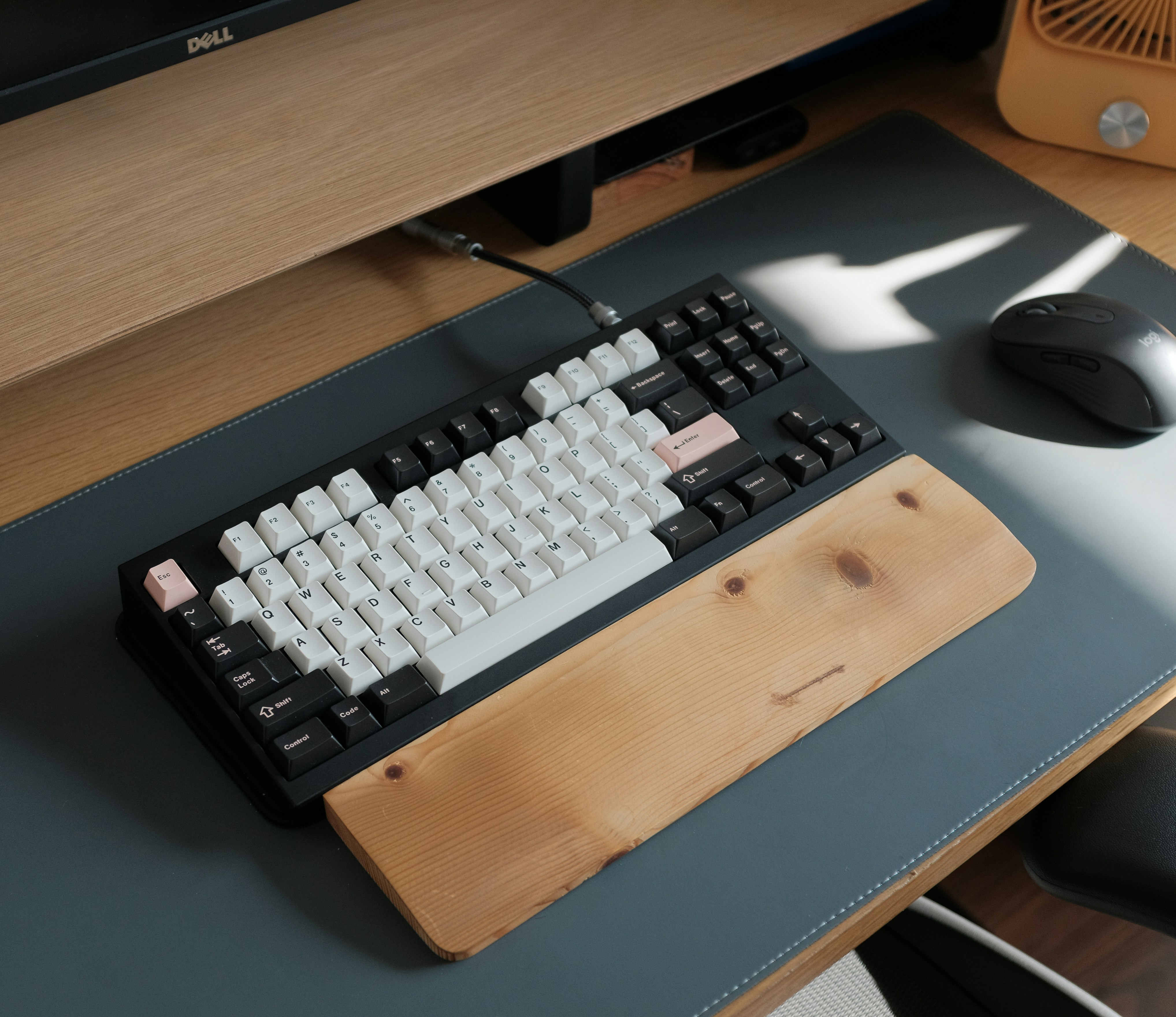 a computer keyboard sitting on top of a wooden desk