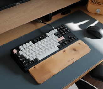 a computer keyboard sitting on top of a wooden desk
