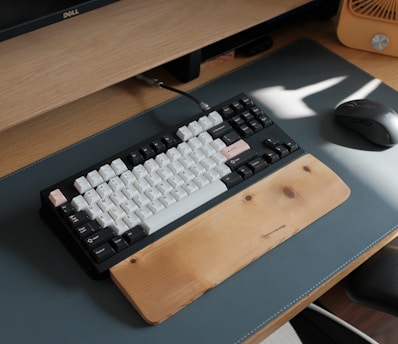 a computer keyboard sitting on top of a wooden desk
