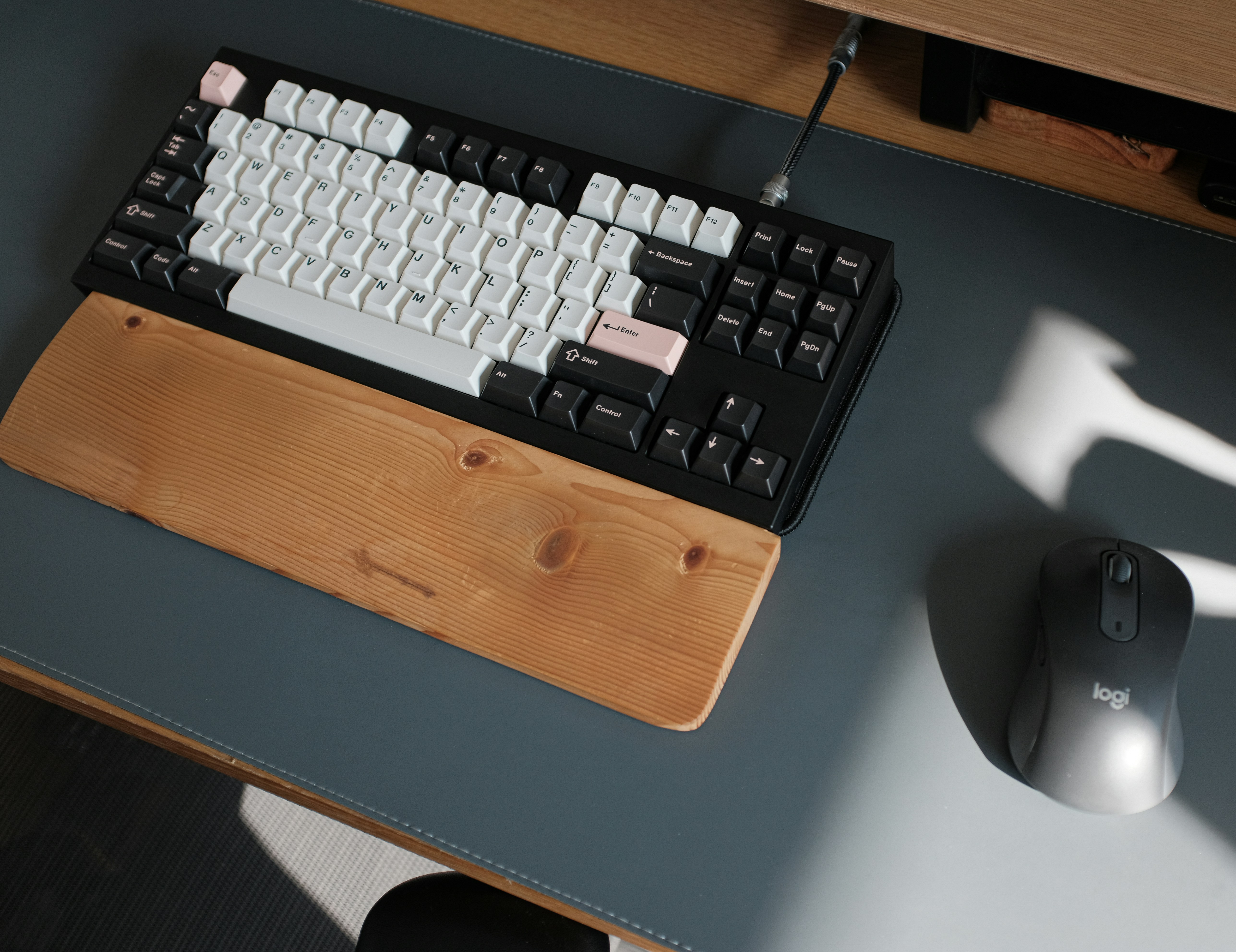 a computer keyboard sitting on top of a wooden desk