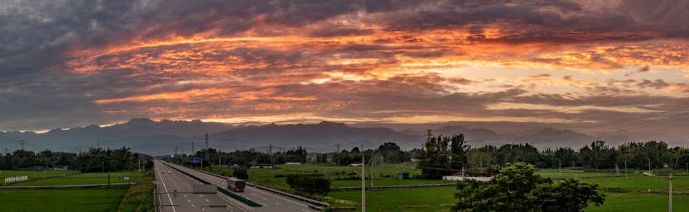 a sunset over a highway in a rural area