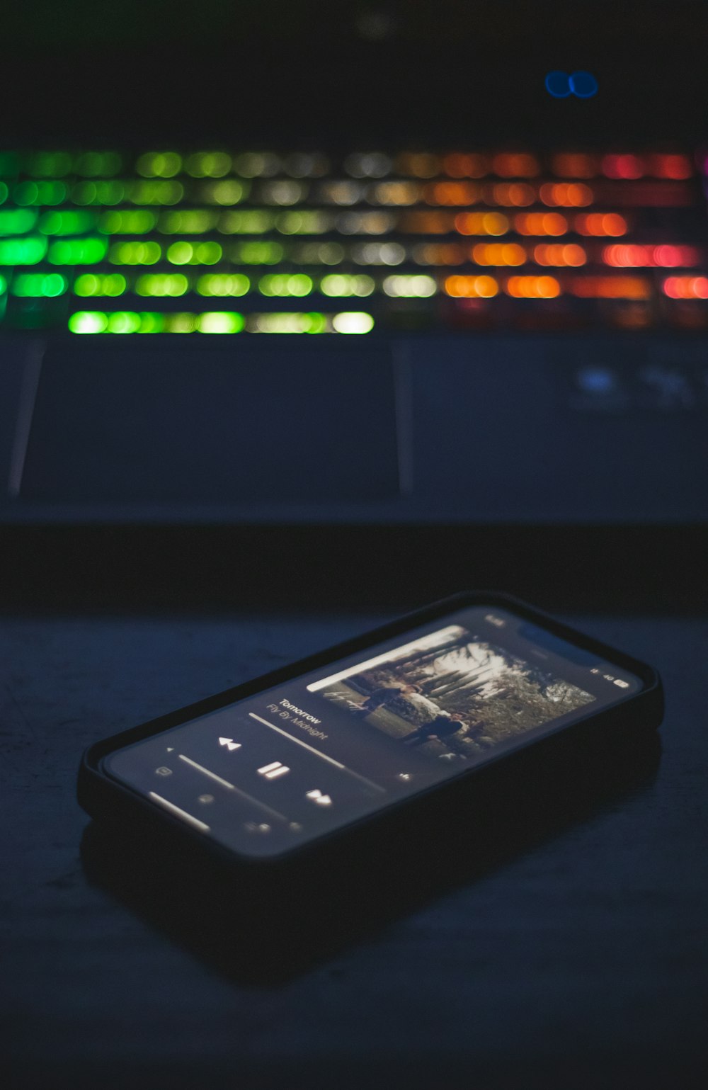 a cell phone sitting in front of a computer keyboard