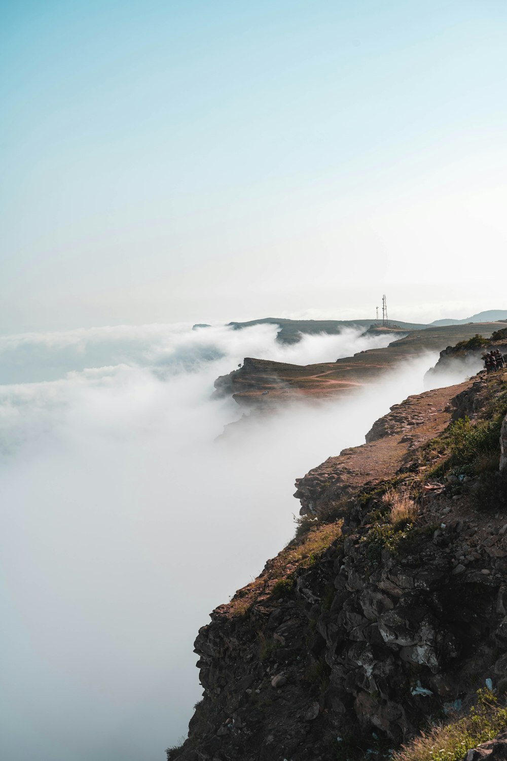 a group of people standing on top of a cliff