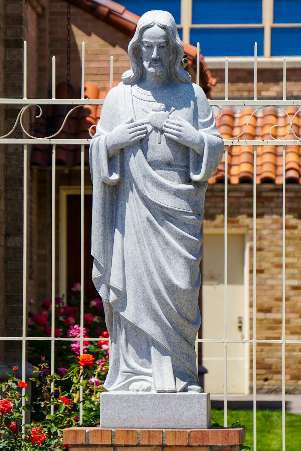 a statue of jesus in front of a house
