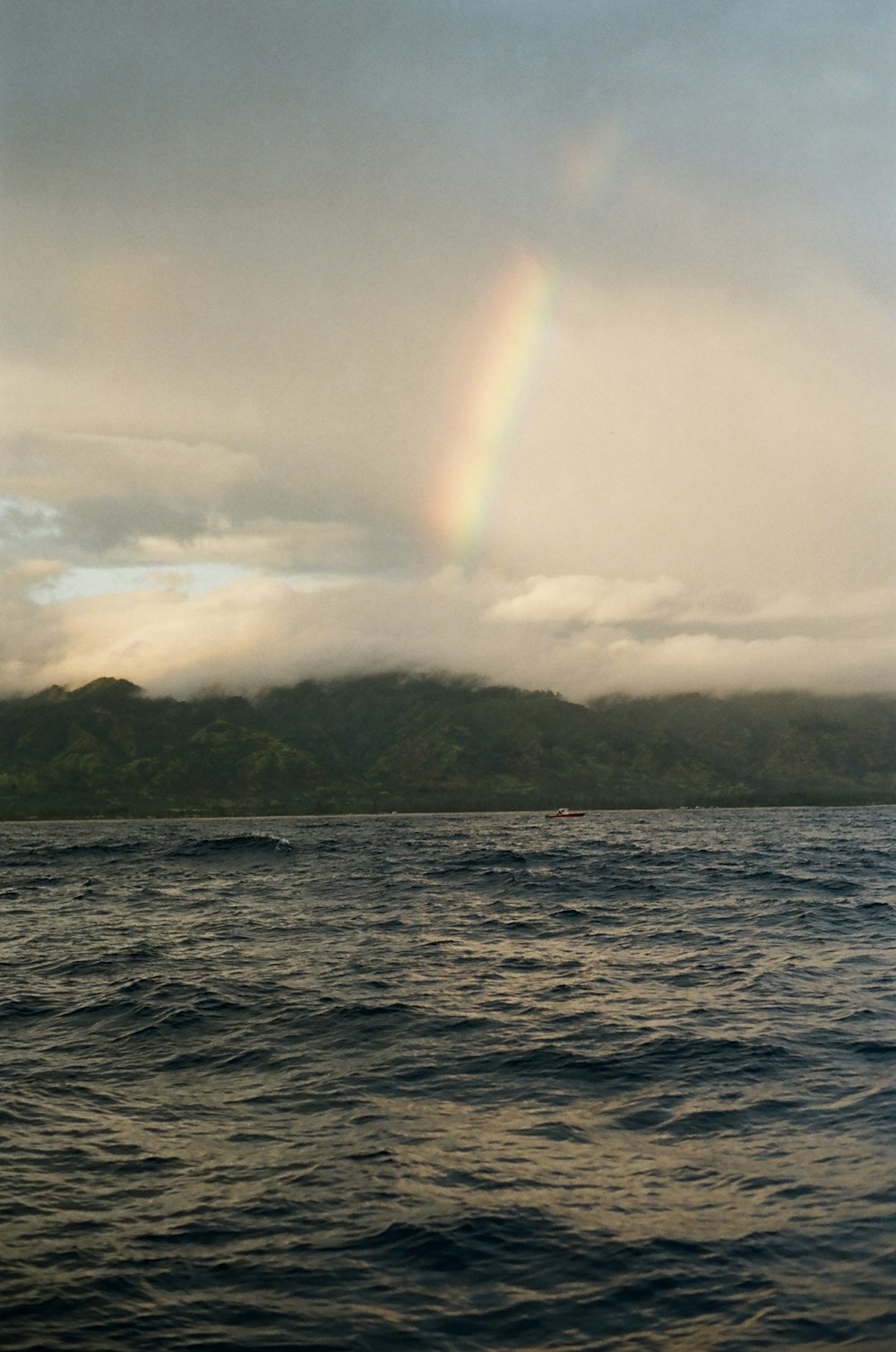 a rainbow in the sky over a body of water