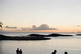 A serene coastal scene with soft clouds over calm Florida waters at dusk.