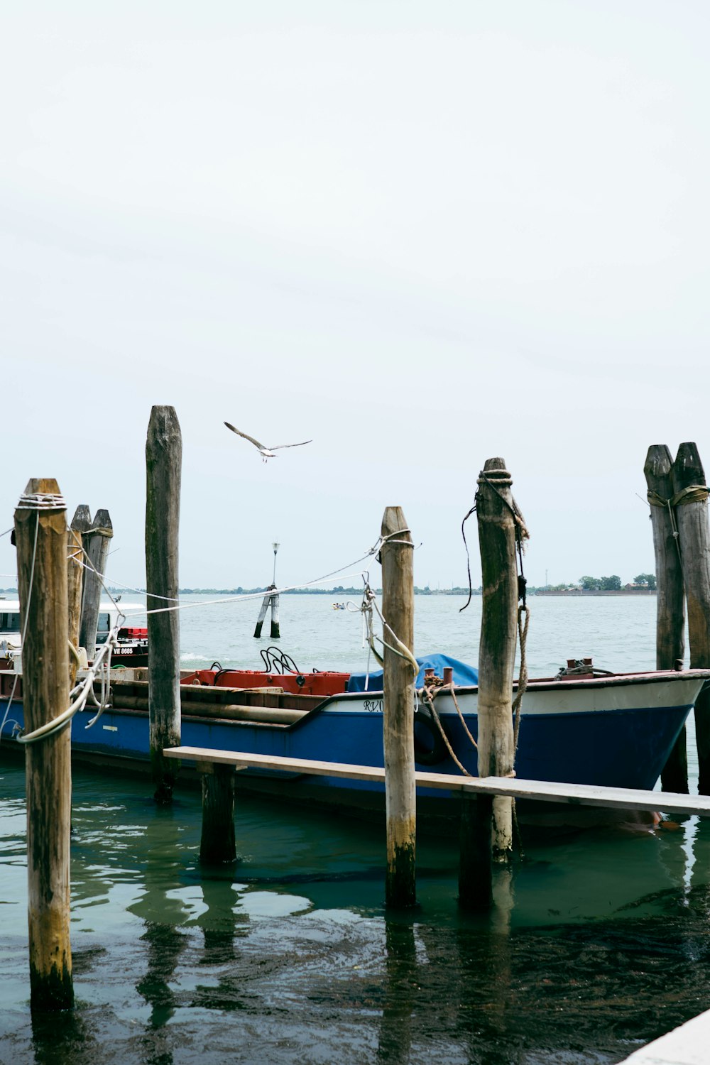 a blue boat tied to a wooden dock