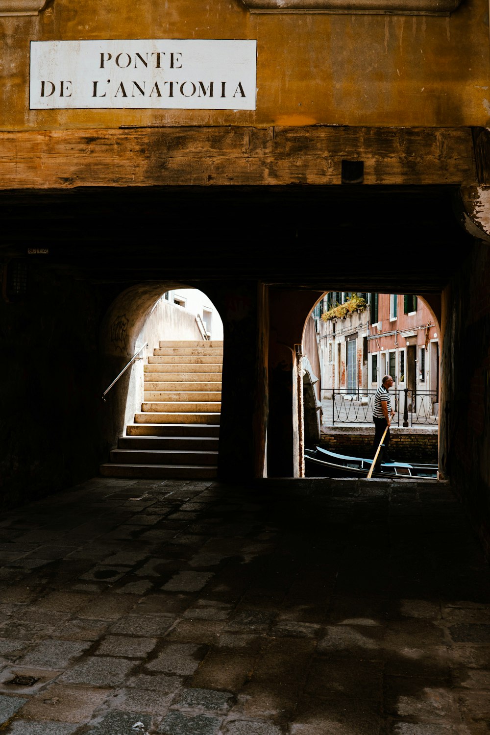 a person walking down a street under a bridge