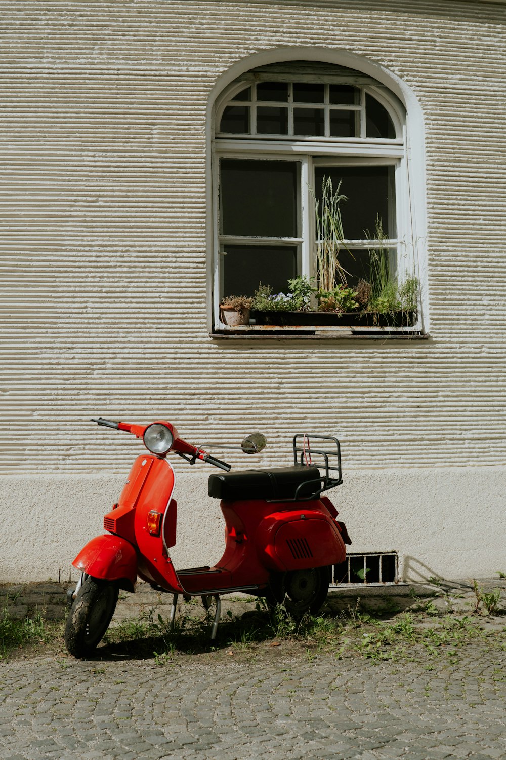 a red scooter parked in front of a building