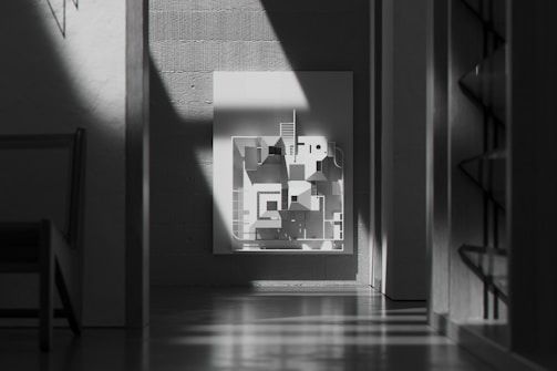 Minimalist black metal frame showcasing modern artwork in a bright office setting.