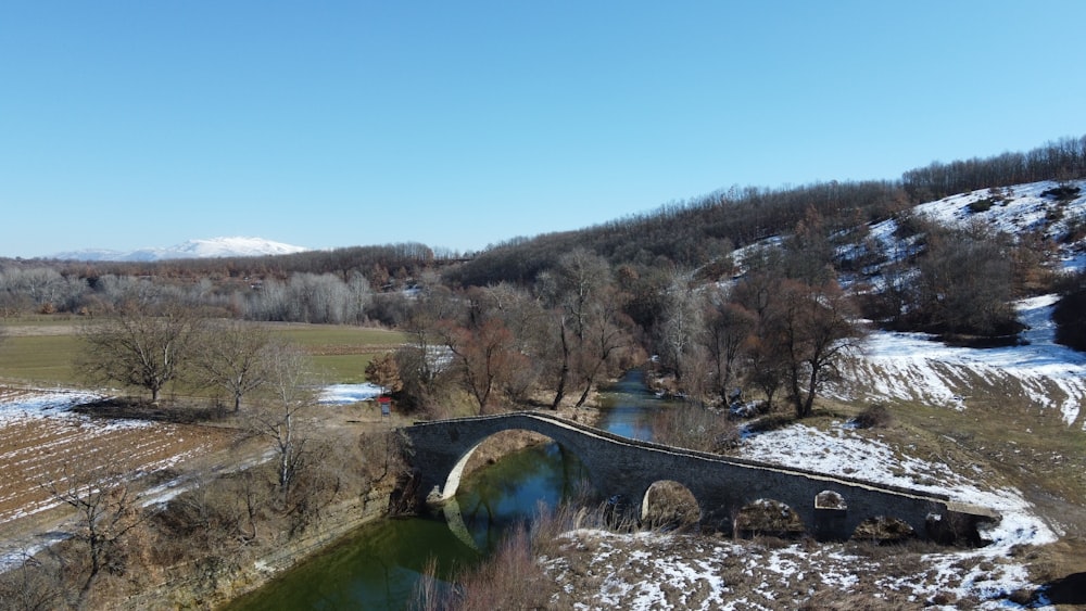 a bridge over a river in a snowy field