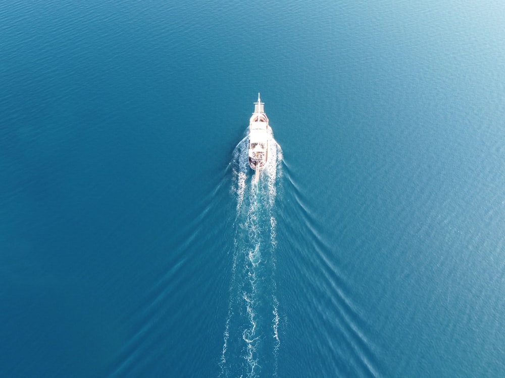 a white boat is in the middle of the water