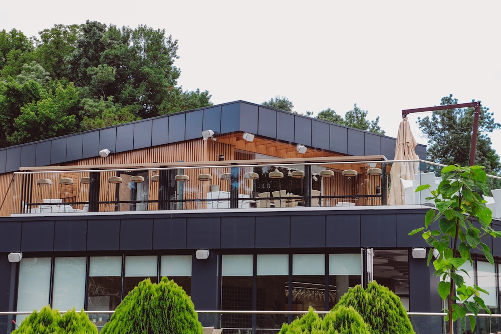 a building with a balcony and trees in the background