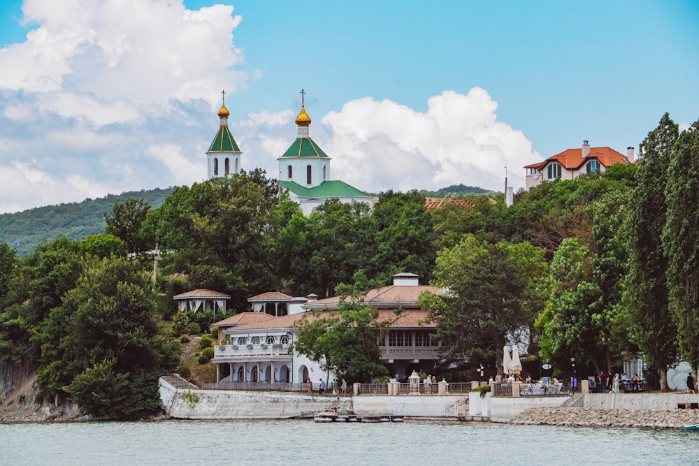 a church on top of a hill next to a body of water