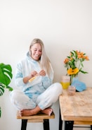 a woman sitting on a stool holding a toothbrush
