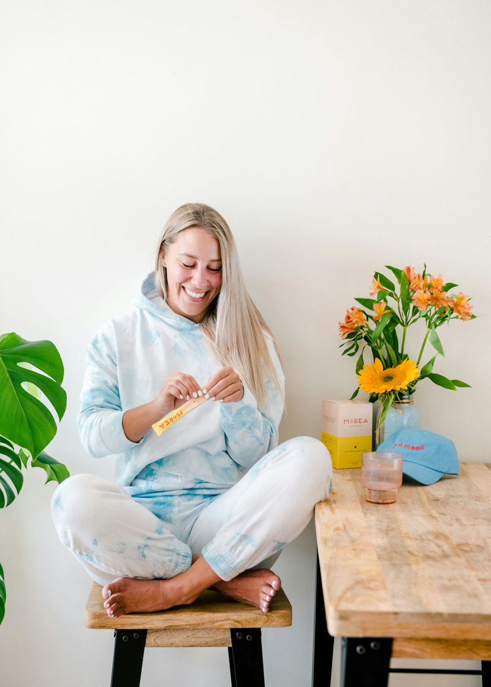 a woman sitting on a stool holding a toothbrush