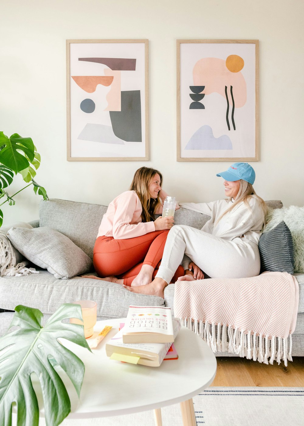 two women sitting on a couch in a living room