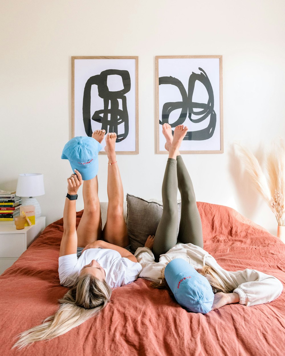 a woman laying on top of a bed with her legs up