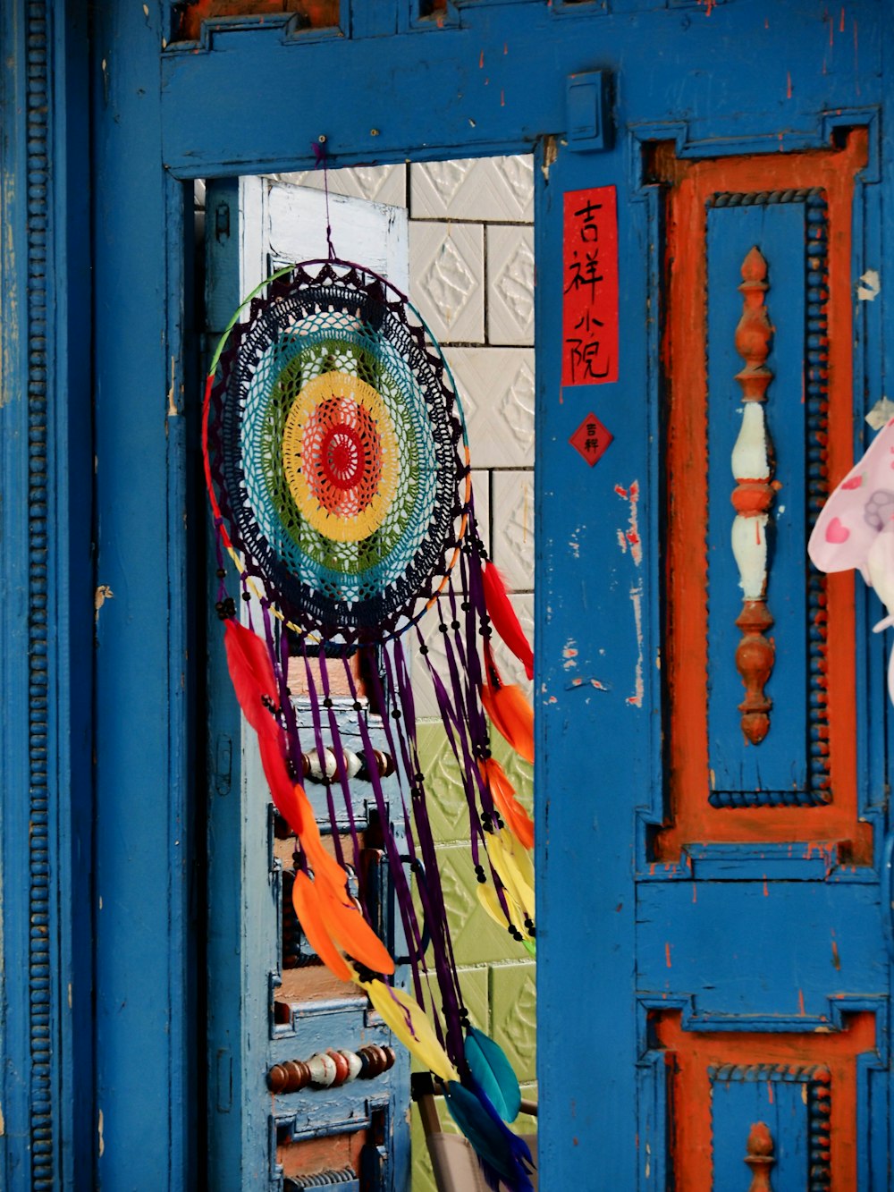 a colorful dream catcher hanging on a blue door