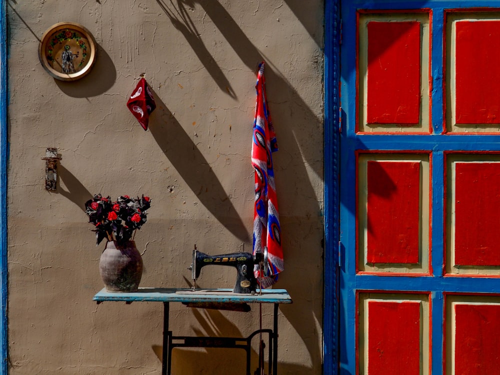 a table with a sewing machine and a vase of flowers