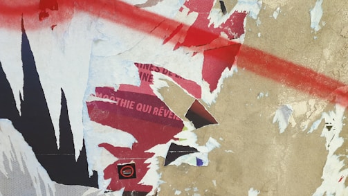 A collage of scrap metal pieces and torn cardboard forming a chaotic background.