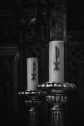 two candles sitting on top of a metal stand
